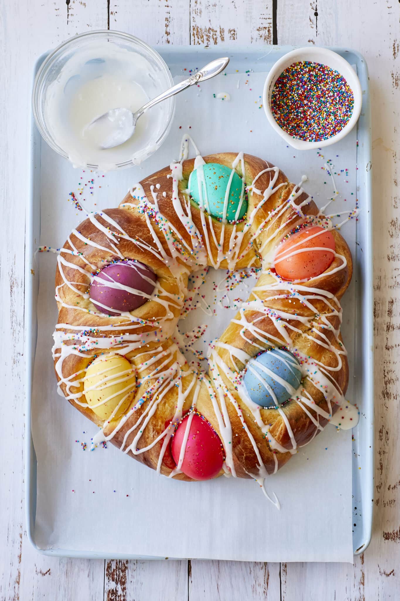 Traditional Italian Easter Bread (Pane di Pasqua) is golden, light and fluffy. It's decorated with colorful Easter eggs, drizzled with icing and topped with colorful sprinkles. 