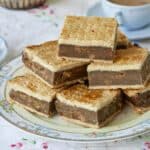 A plate of Irish Gum Cakes are served with tea. The Fur Cakes have golden flaky top and bottom crust, filled with moist breadcrumbs, spices, and sweet raisins.