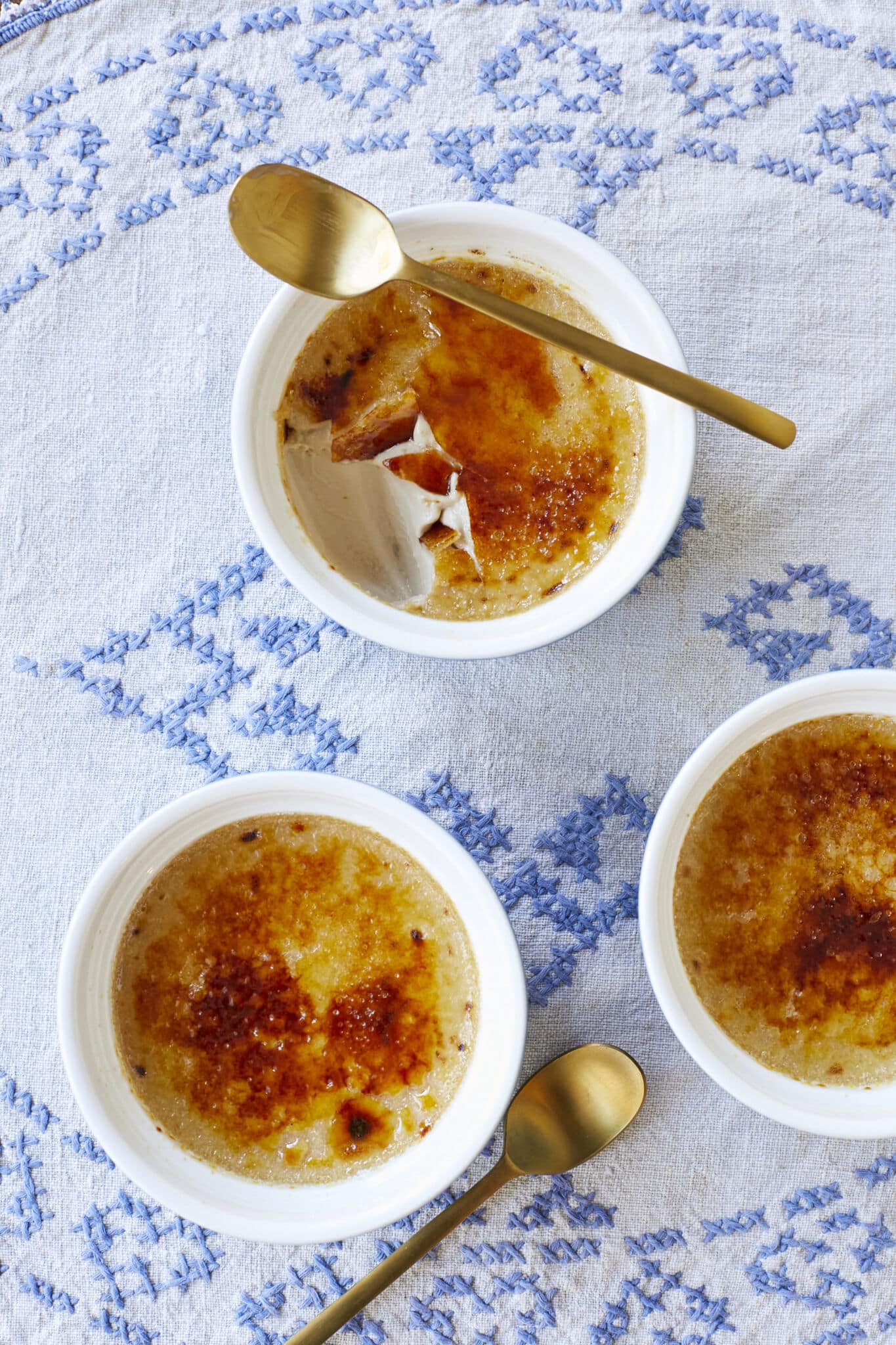 An overhead shot of 3 ramekins of Irish Whiskey Crème Brûlée shows the caramelized crunch top and silky smooth custard interior.