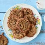 Crispy, chewy Almond Flour Cinnamon Raisin Cookies are served on a big platter with two glasses of milk.