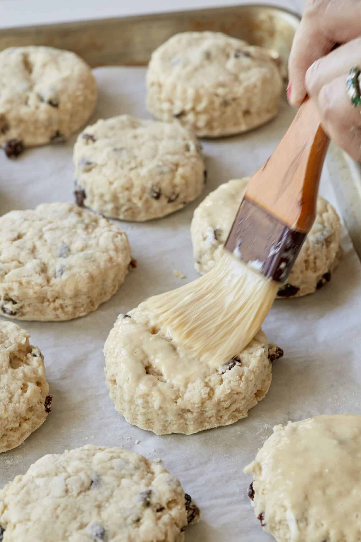 Step-by-step instructions on how to make scones: brush the scones with egg what before baking.