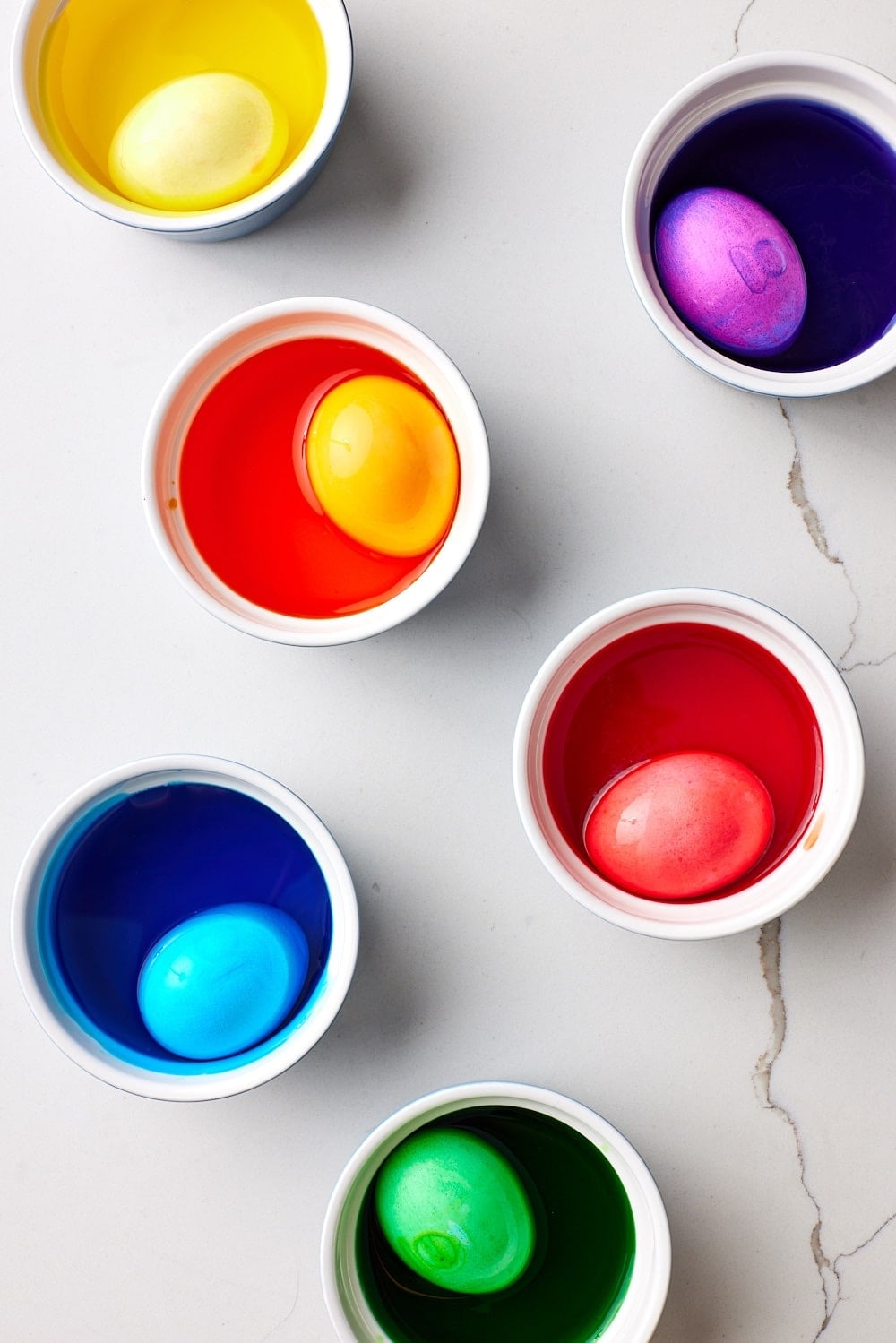 Submerge eggs into colored water in paper cups for Italian Easter Bread. 