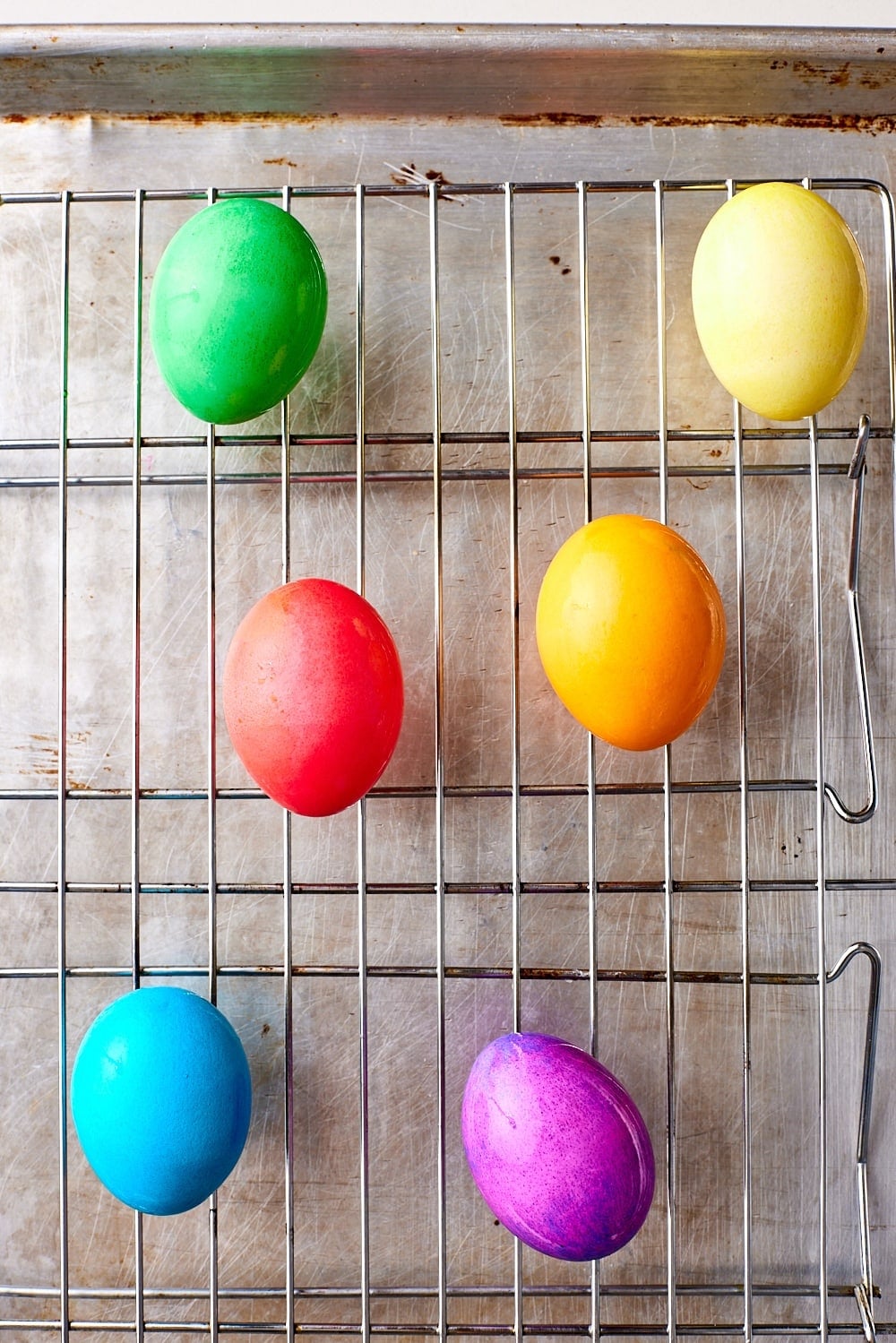 Drying colored eggs on a cooling rack. 