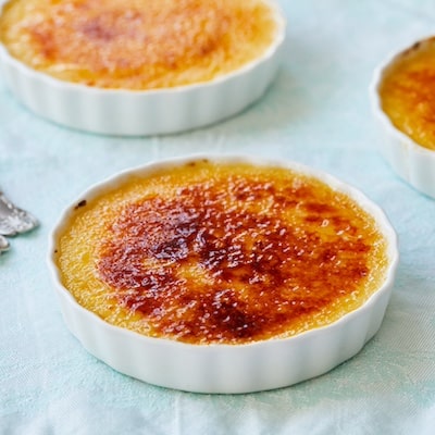 Three dishes of Passionfruit Crème Brûlée is served. Each Passionfruit Crème Brûlée has a rich custard base topped with a layer of amber-color caramelized sugar.