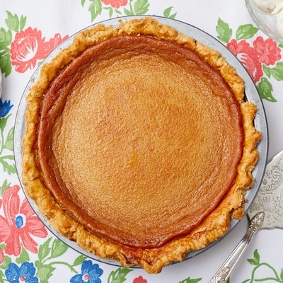 A top-down view of a whole Honey Pie with golden crust and smooth, gooey filling.