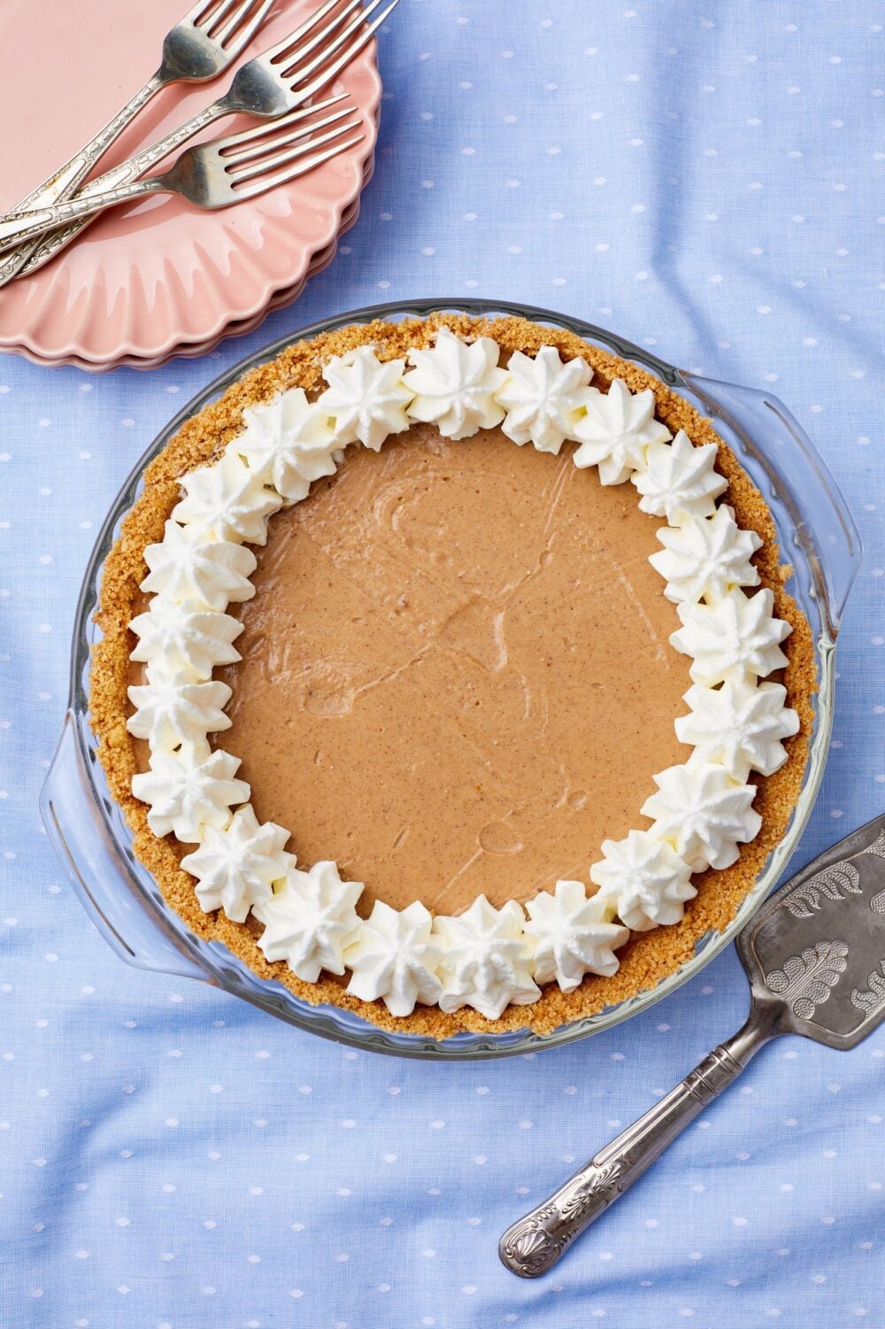 pumpkin cream pie 9 Top down view of a whole pumpkin cream pie topped with whipped cream rosettes.