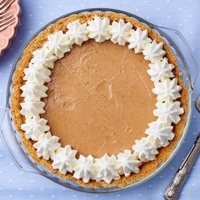 Pumpkin Cream Pie with golden cookie crust and gooey filling is served with rosette of whipped cream.