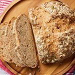 A top-down view of the Seeded Bread shows its bubbly crumb, golden crust with loaded of seeds.