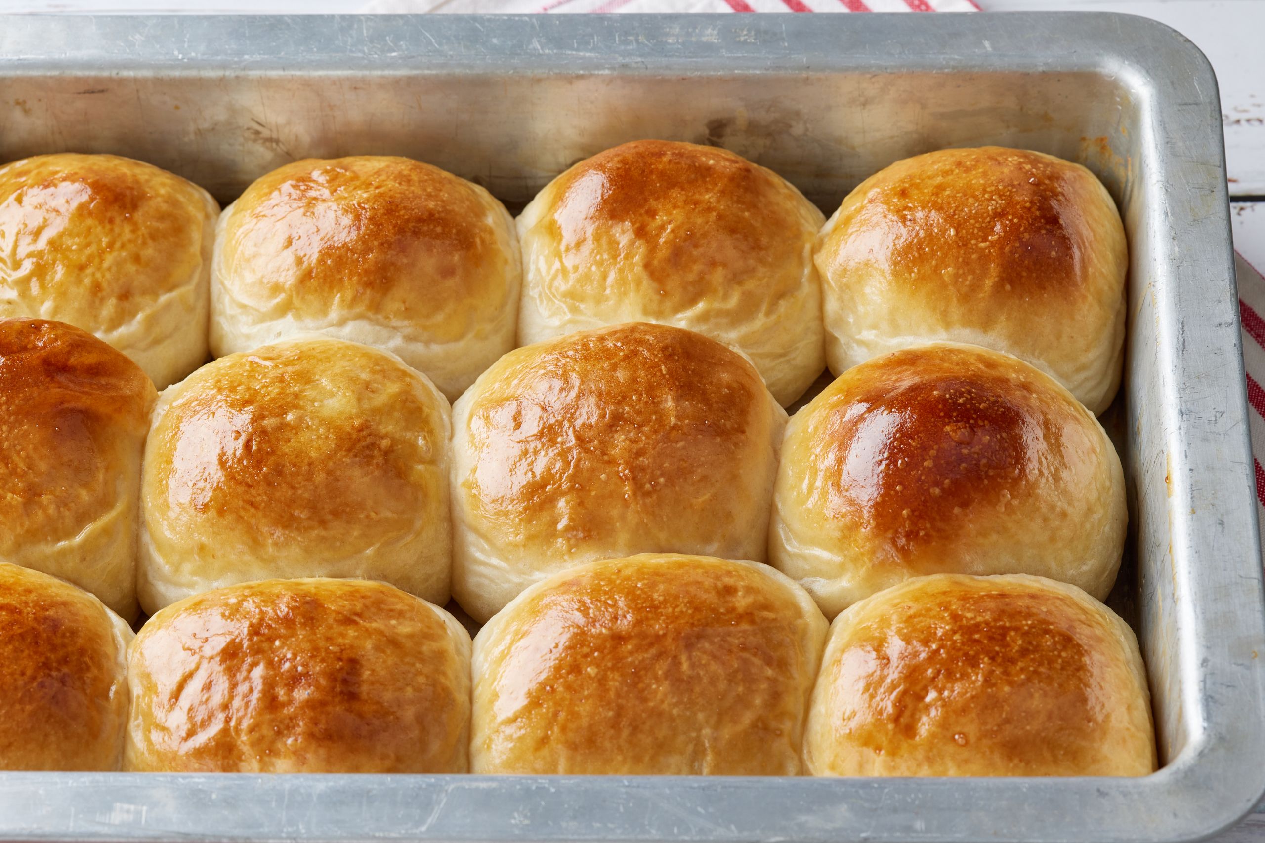 A tray of golden fluffy sourdough dinner rolls