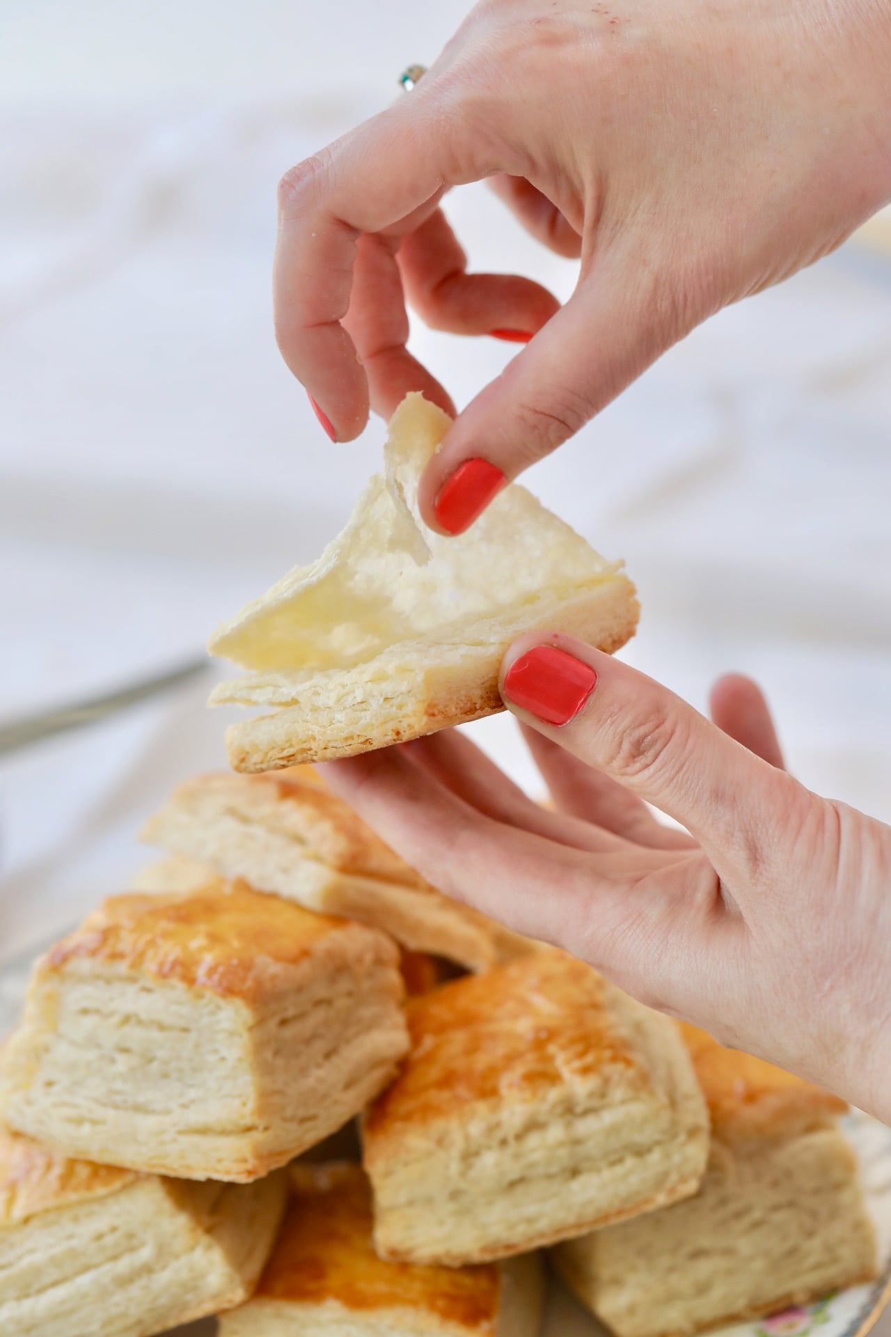 Laminated Biscuits15 Above a pile of biscuits, one is being pulled apart wooing its layers.