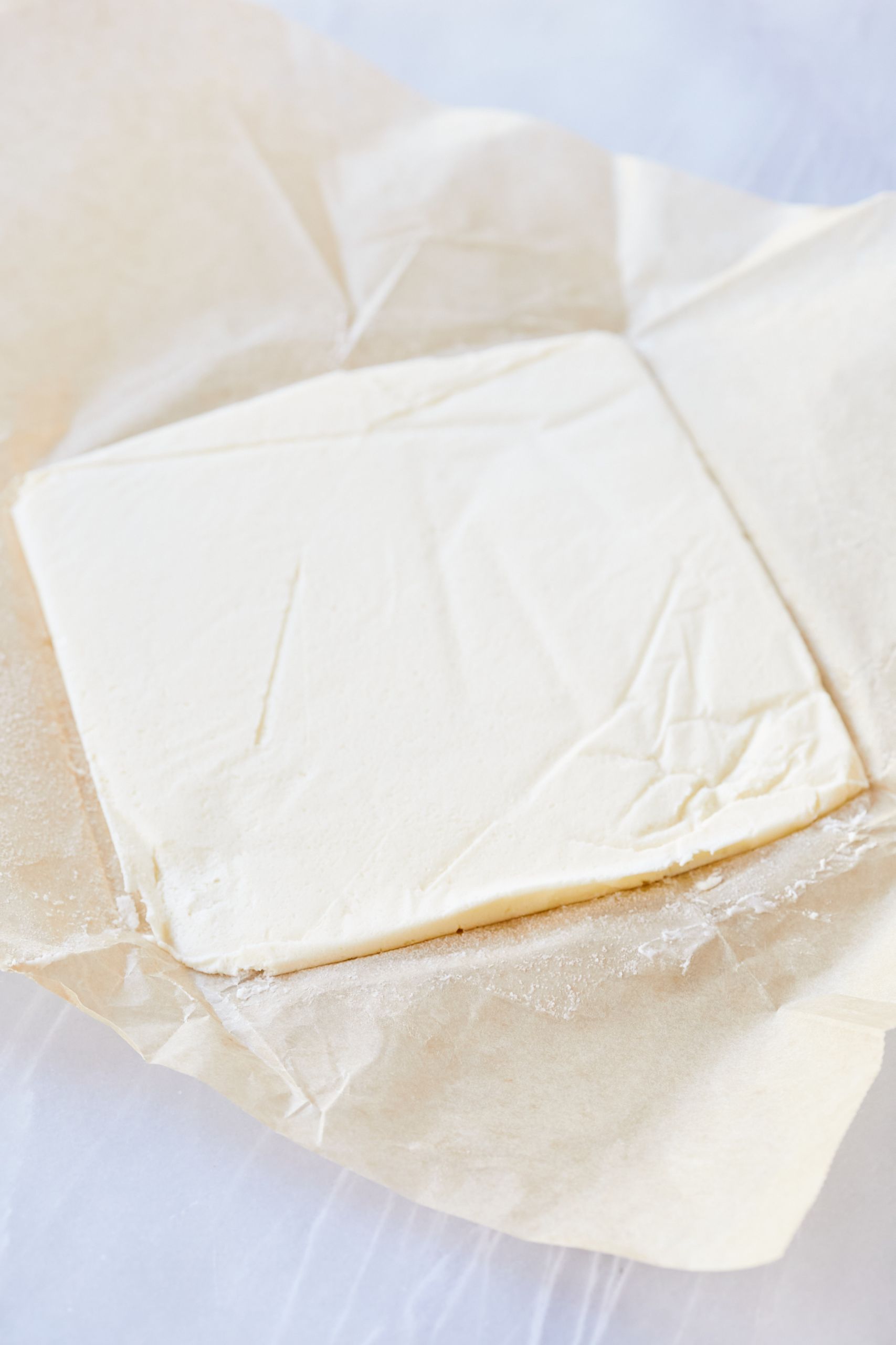 Laminated Biscuits2 Prepare butter for the laminated dough: Fold the parchment around the butter, and using a rolling pin, flatten the butter into the square shape.