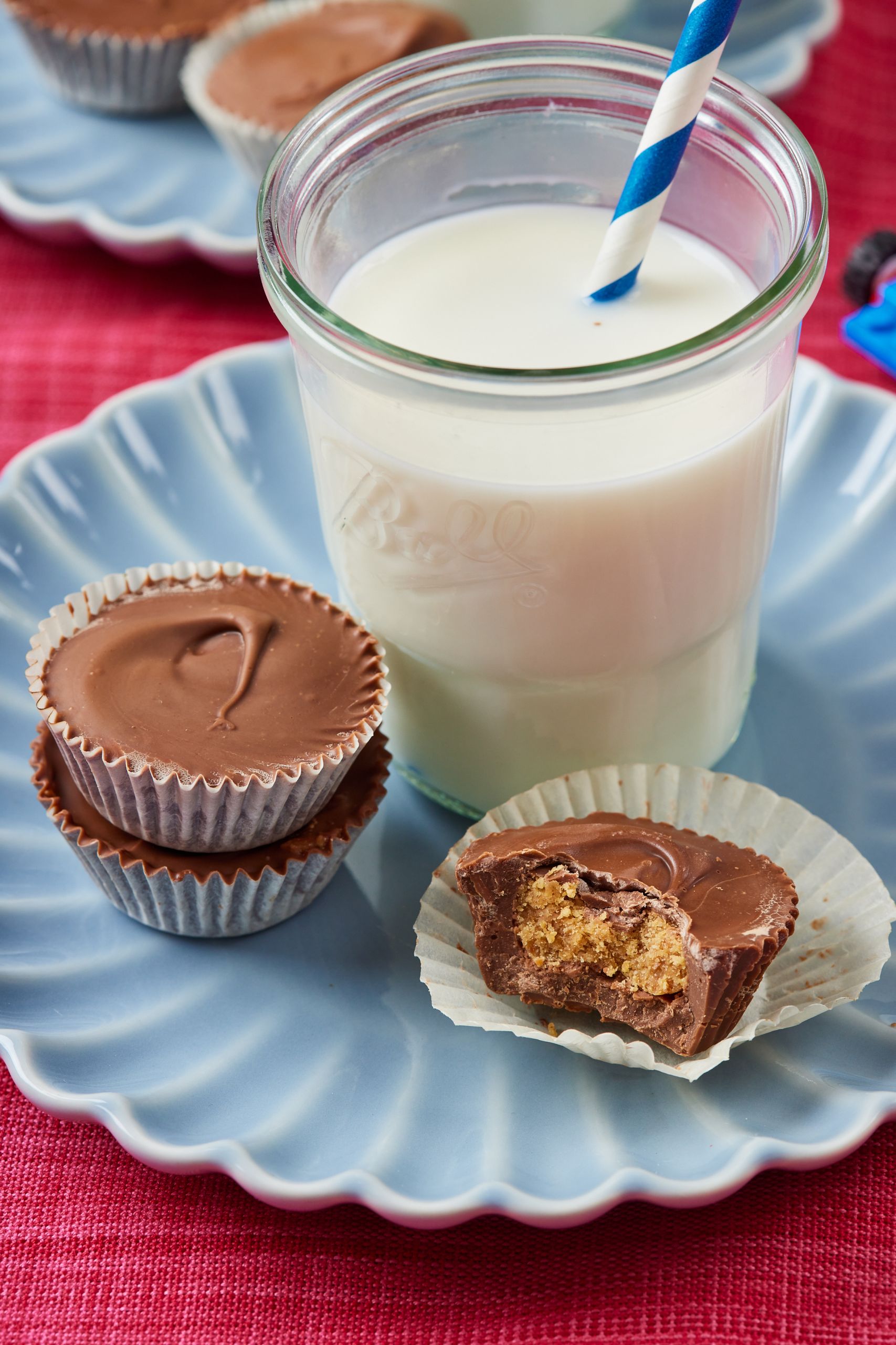 Peanut Butter Cups paired with milk. One has been taken a bite of and it shows the filling