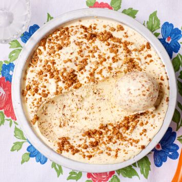 A top-down view of a bowl of Brown Bread Ice Cream with one ball scooped.