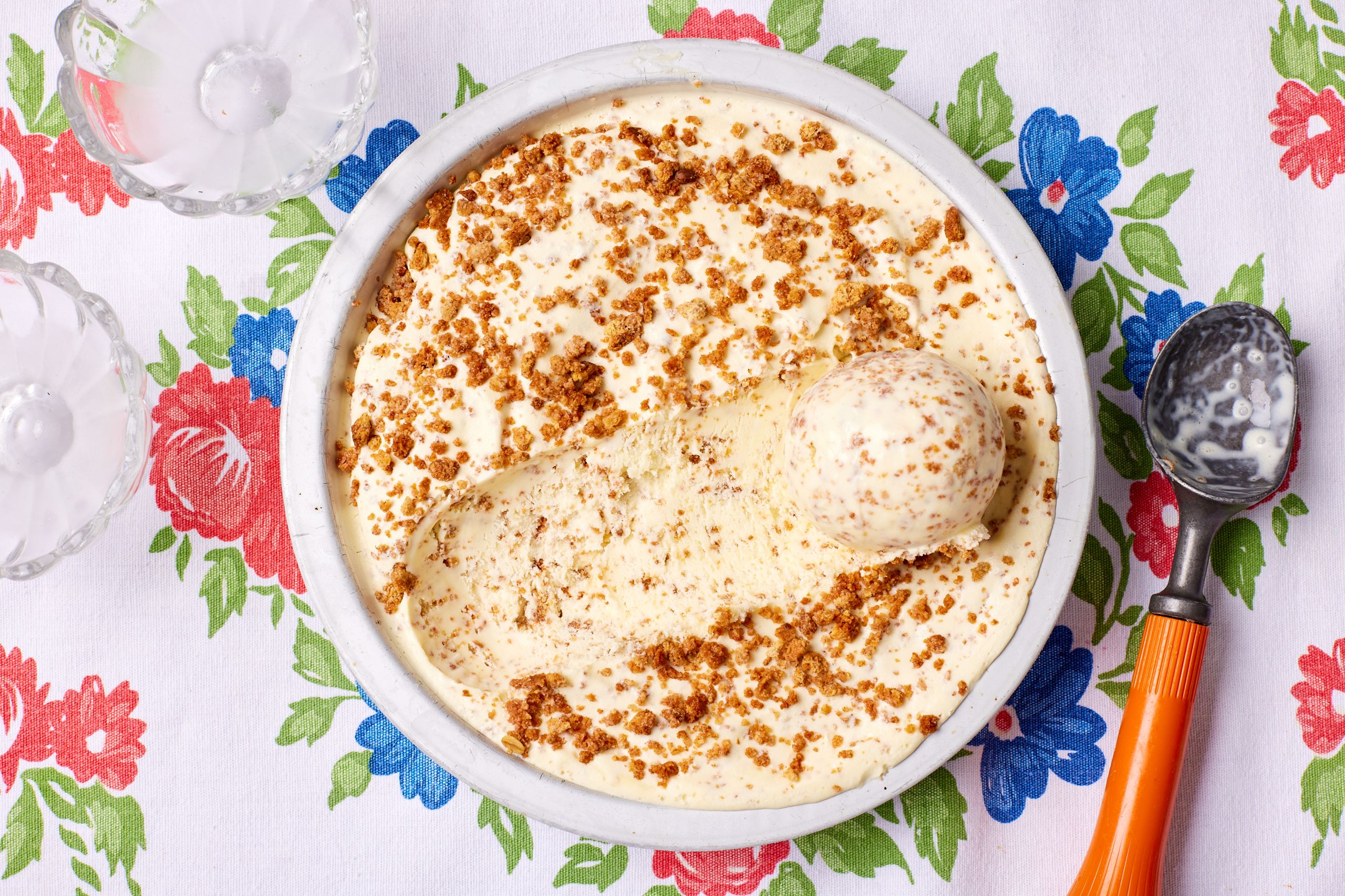 A top-down view of a bowl of Brown Bread Ice Cream with one ball scooped.