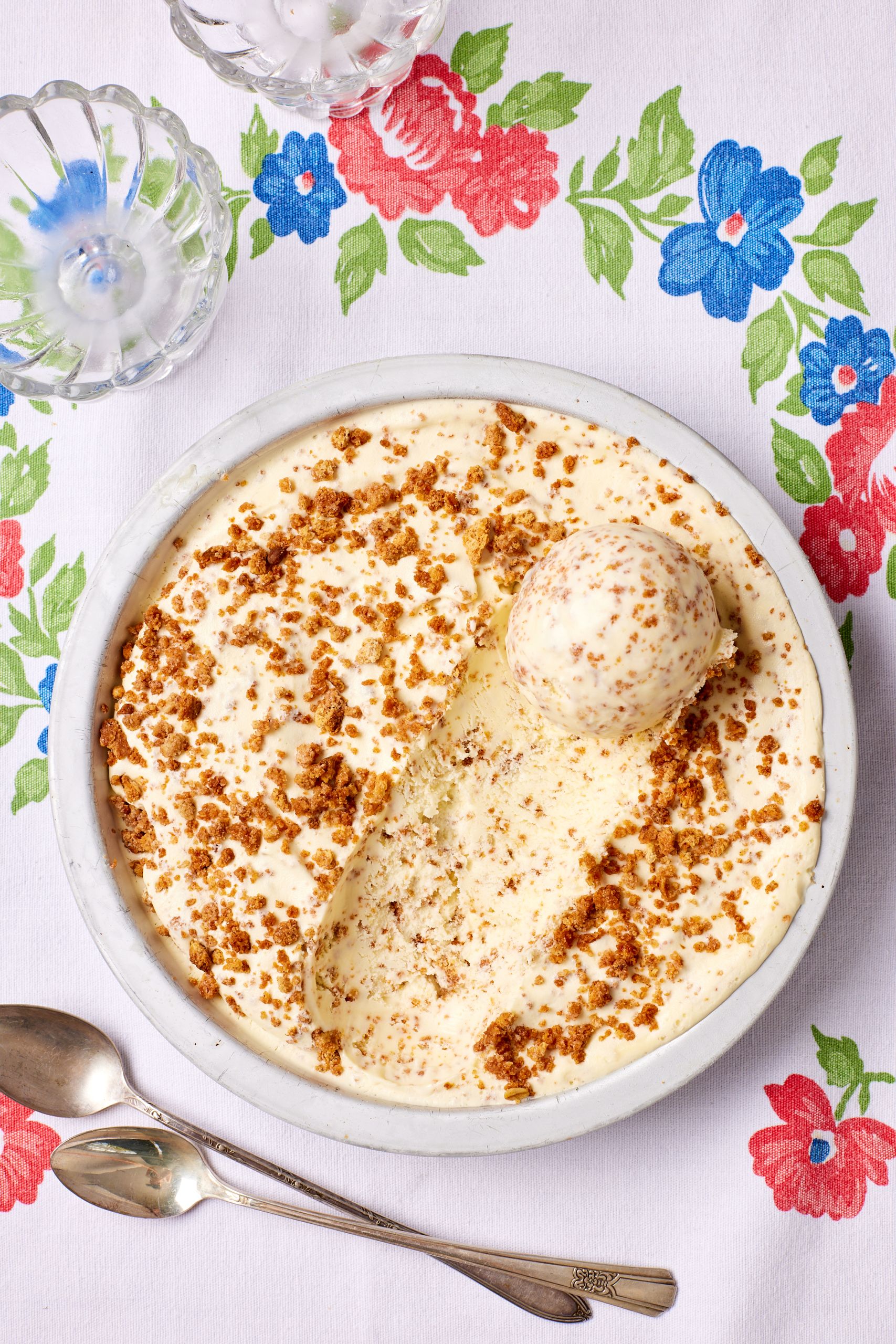A top-down view of a bowl of Brown Bread Ice Cream with one ball scooped.