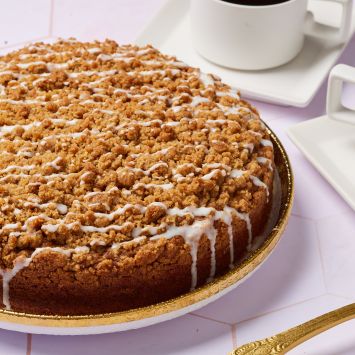 Irish Coffee Cake with golden brown Streusel topping and white vanilla glaze. Served with coffee.