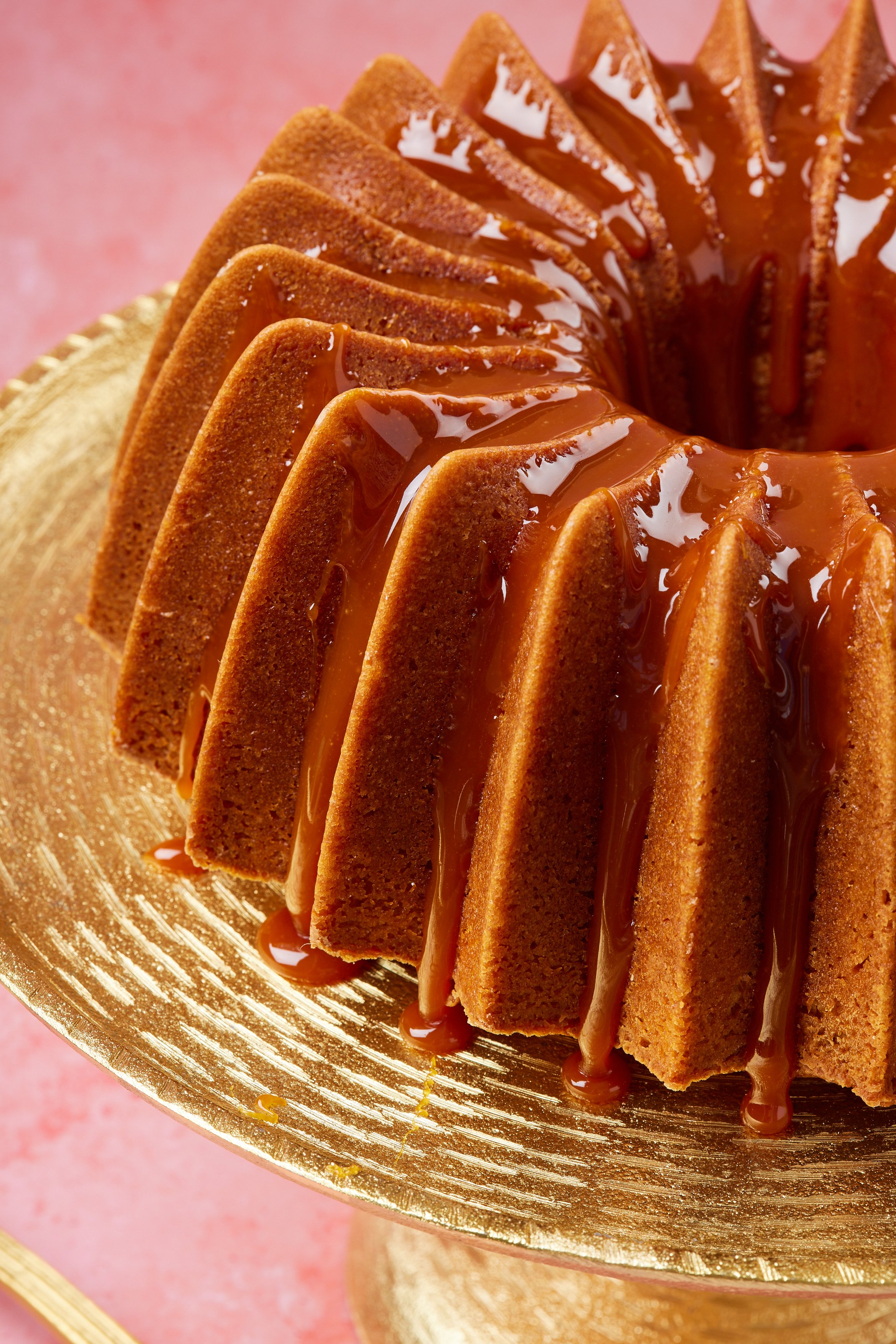 A close-up shot at the side of the Whiskey Cake shows its golden brown color, moist fine crumb and glossy glaze. 