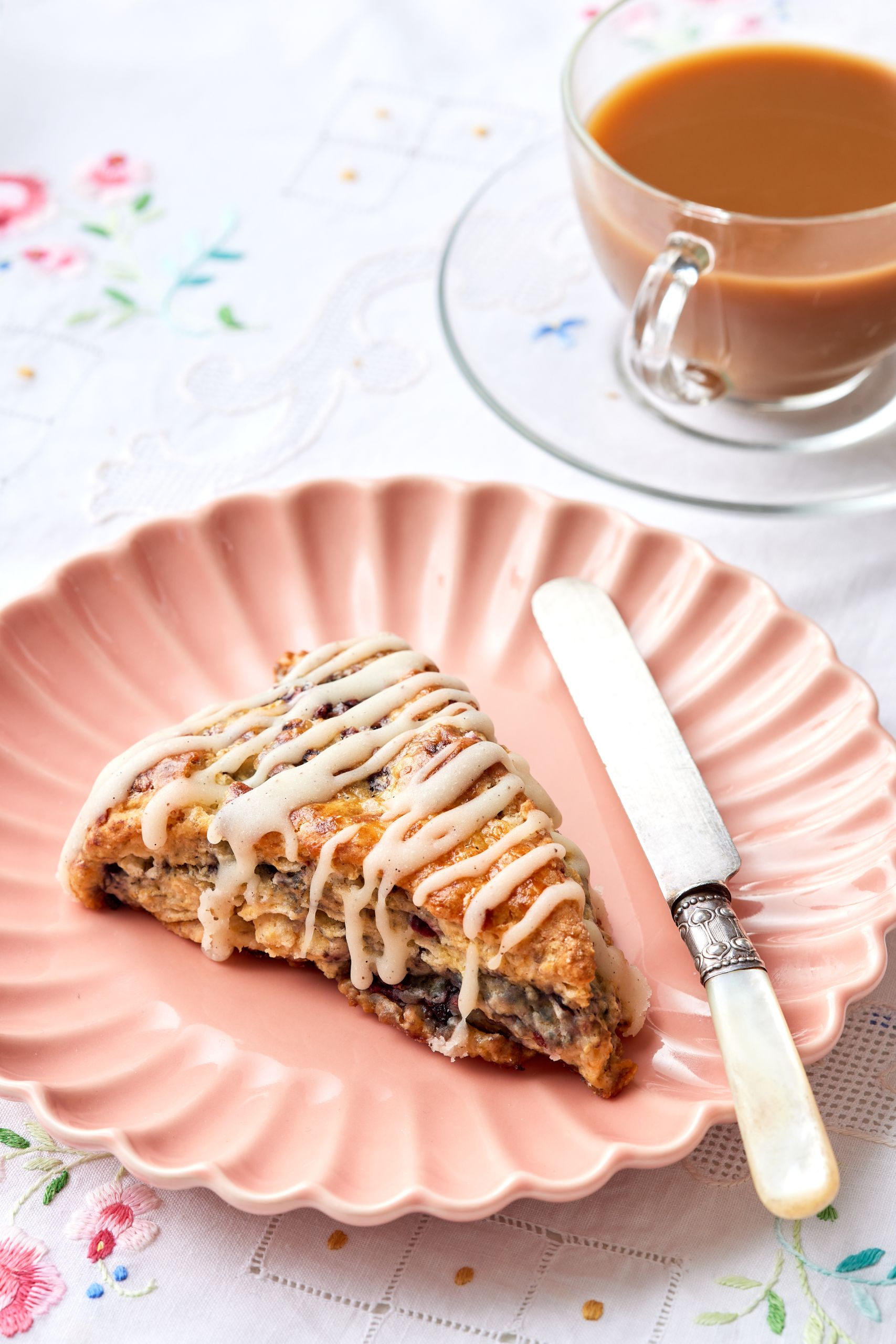 A slice of blackberry scone served with tea.