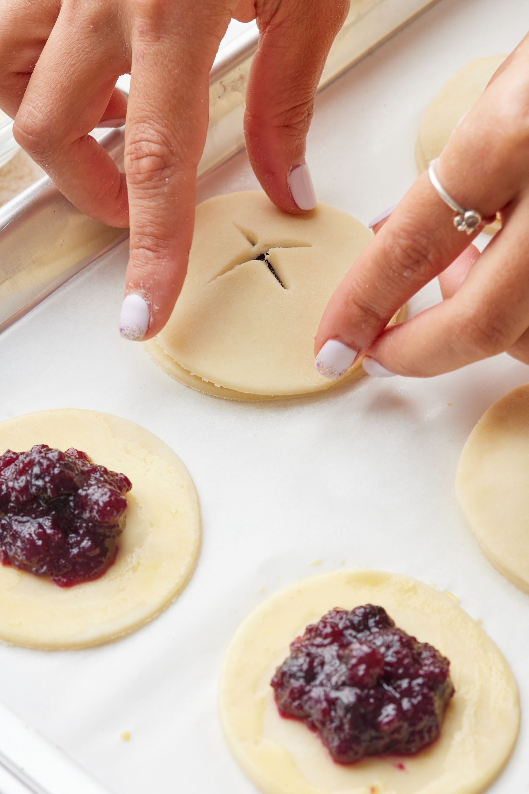 Use a thin, sharp knife to cut a small 'x' in the center of the remaining circles of pie dough, then top each of the filled circles.