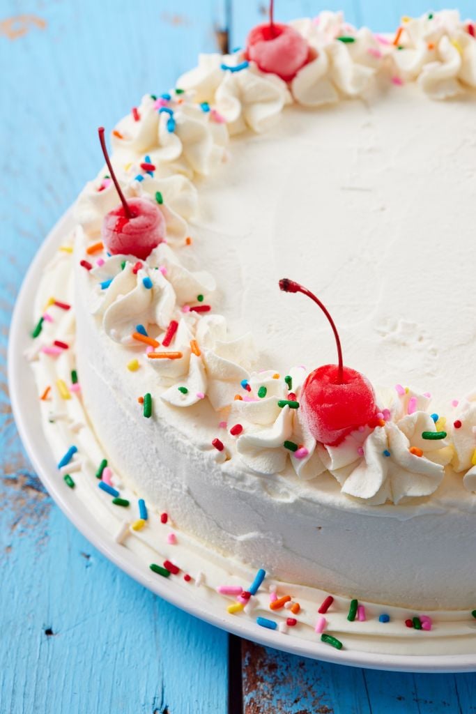 Ice Cream Cake decorated with whipped cream rosette, sprinkles, and maraschino cherries.