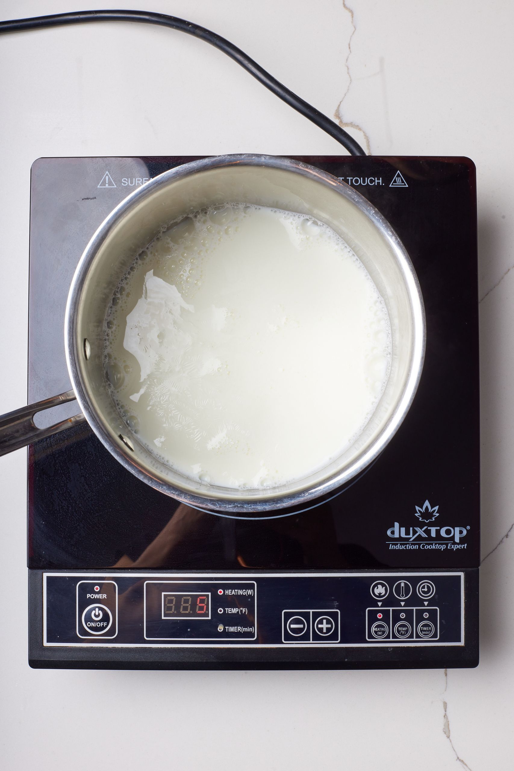 Step-by-step instructions on how to make Whiskey Ice Cream: warm milk. 