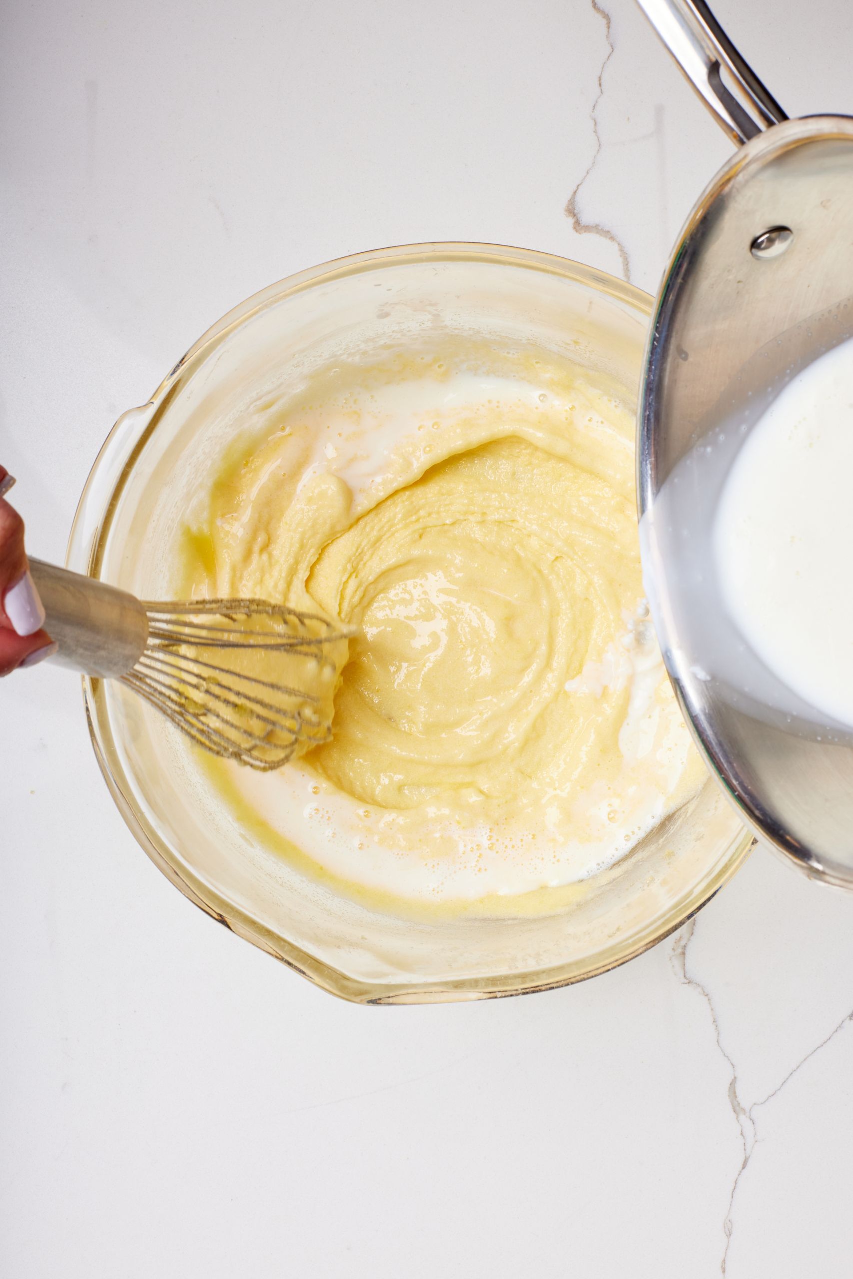 Pour simmered milk in the egg yolk mixture one spoon at a time until all evenly incoperated. 