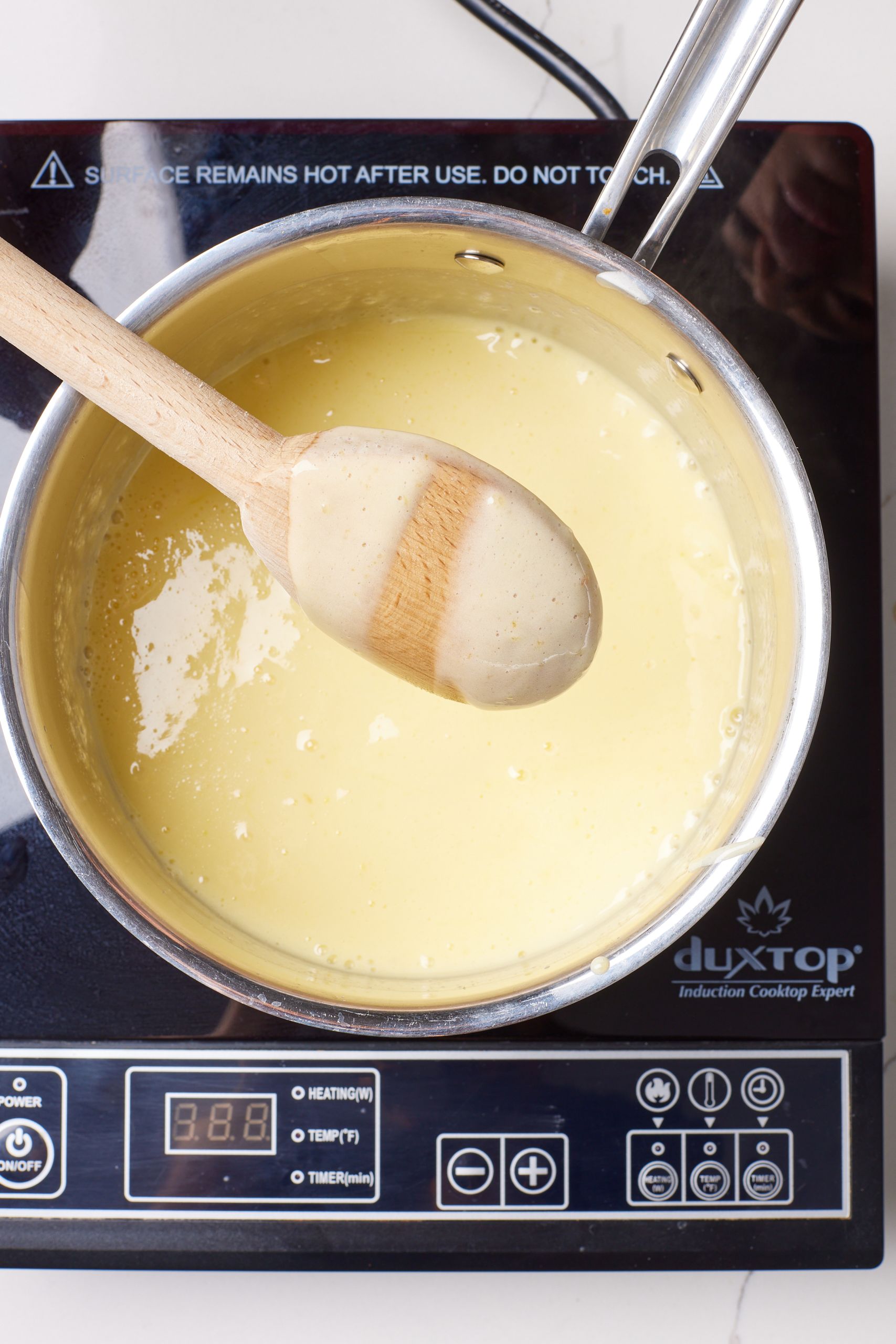 Return the custard mixture to the heat until it thickens and coats the back of a spoon.