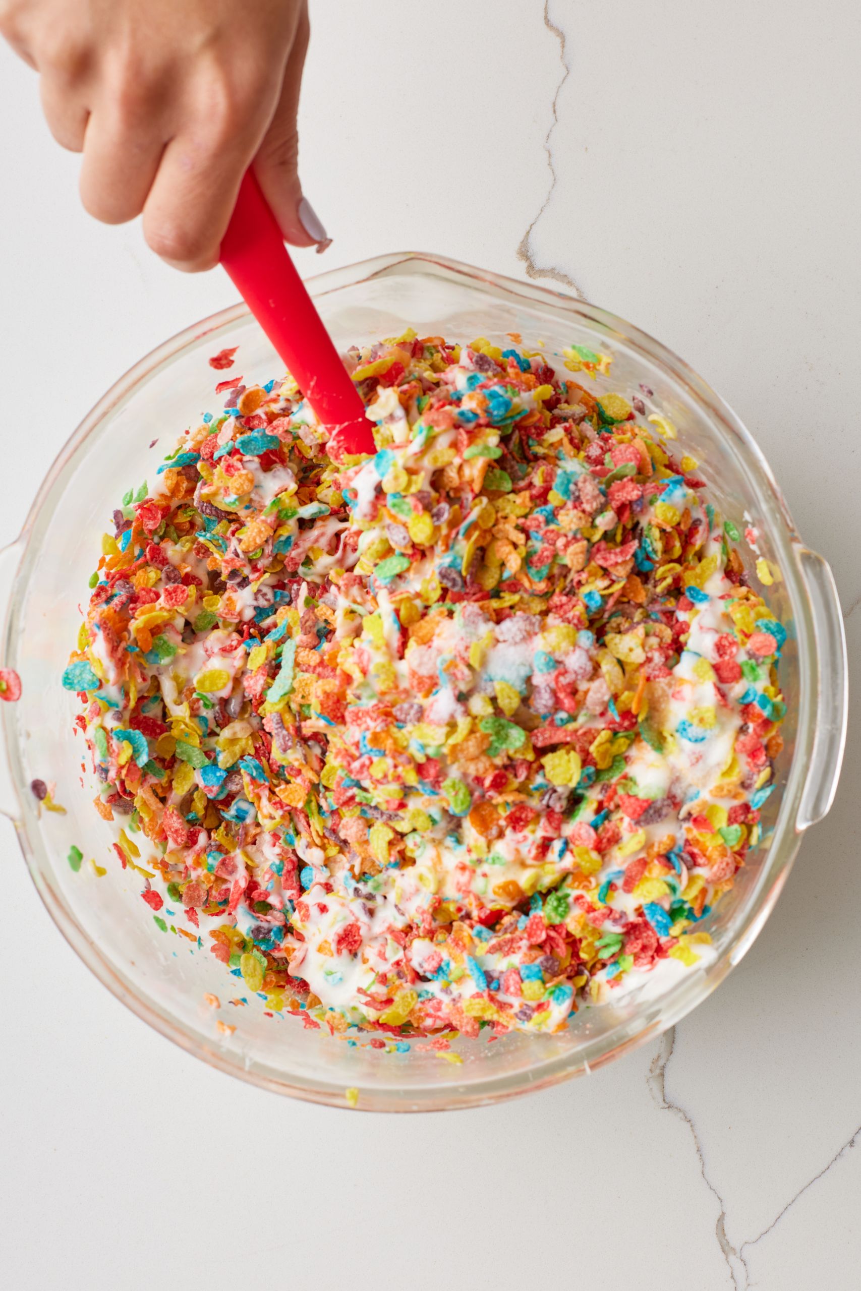 Using a greased spatula, fold in the Fruity Pebbles, vanilla and salt until the cereal is evenly coated.