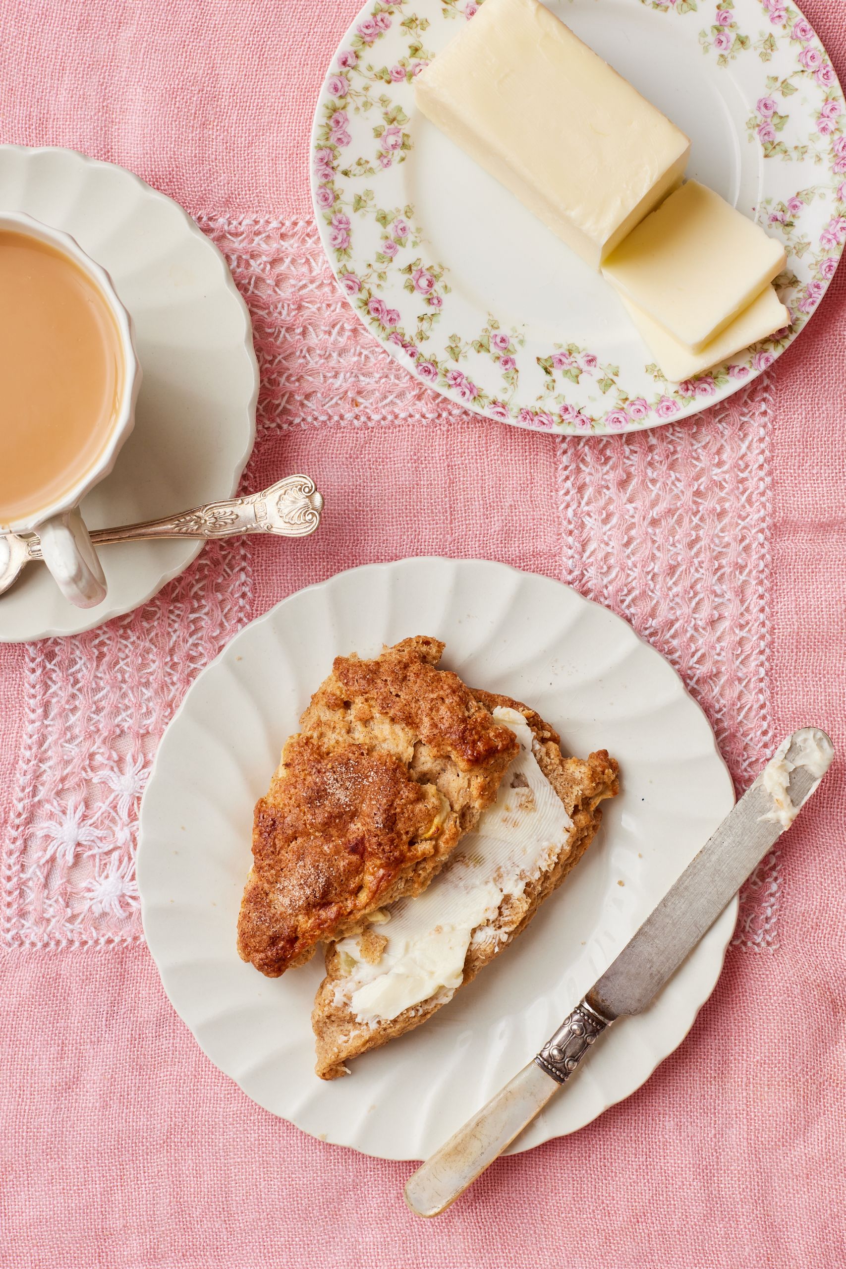 Scones served with butter, whipped cream ,and tea.