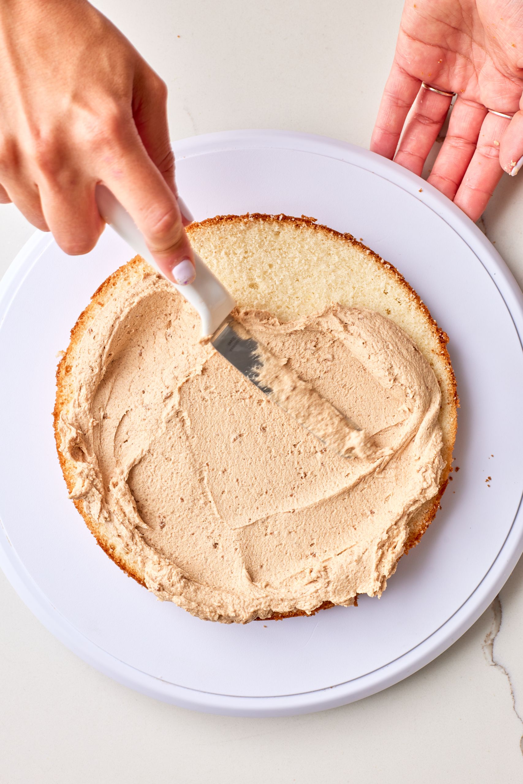 Use an offset spatula to spread the frosting all the way to the edges of the layer.