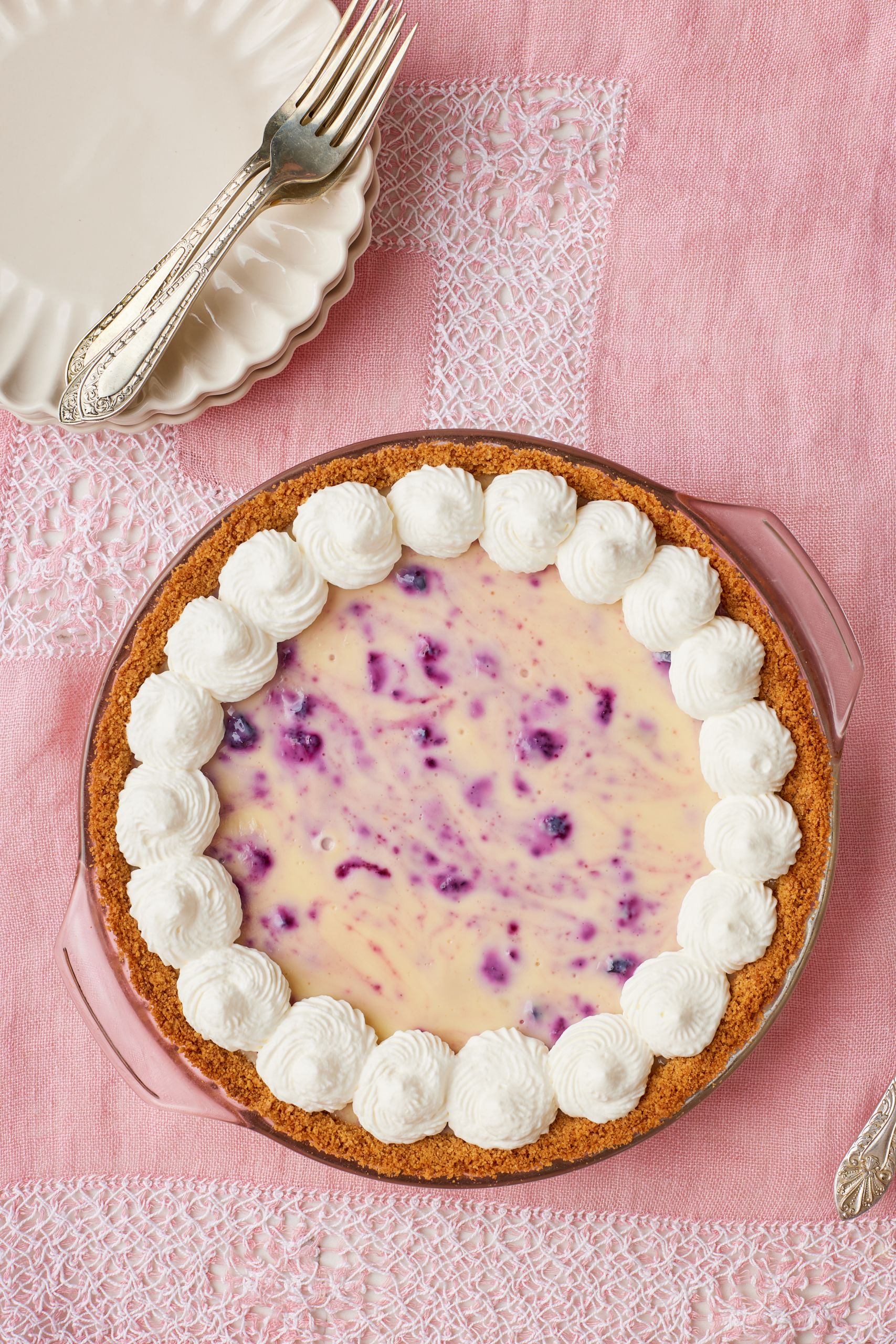 A top-down view of lemon blueberry pie decorated with whipped cream
