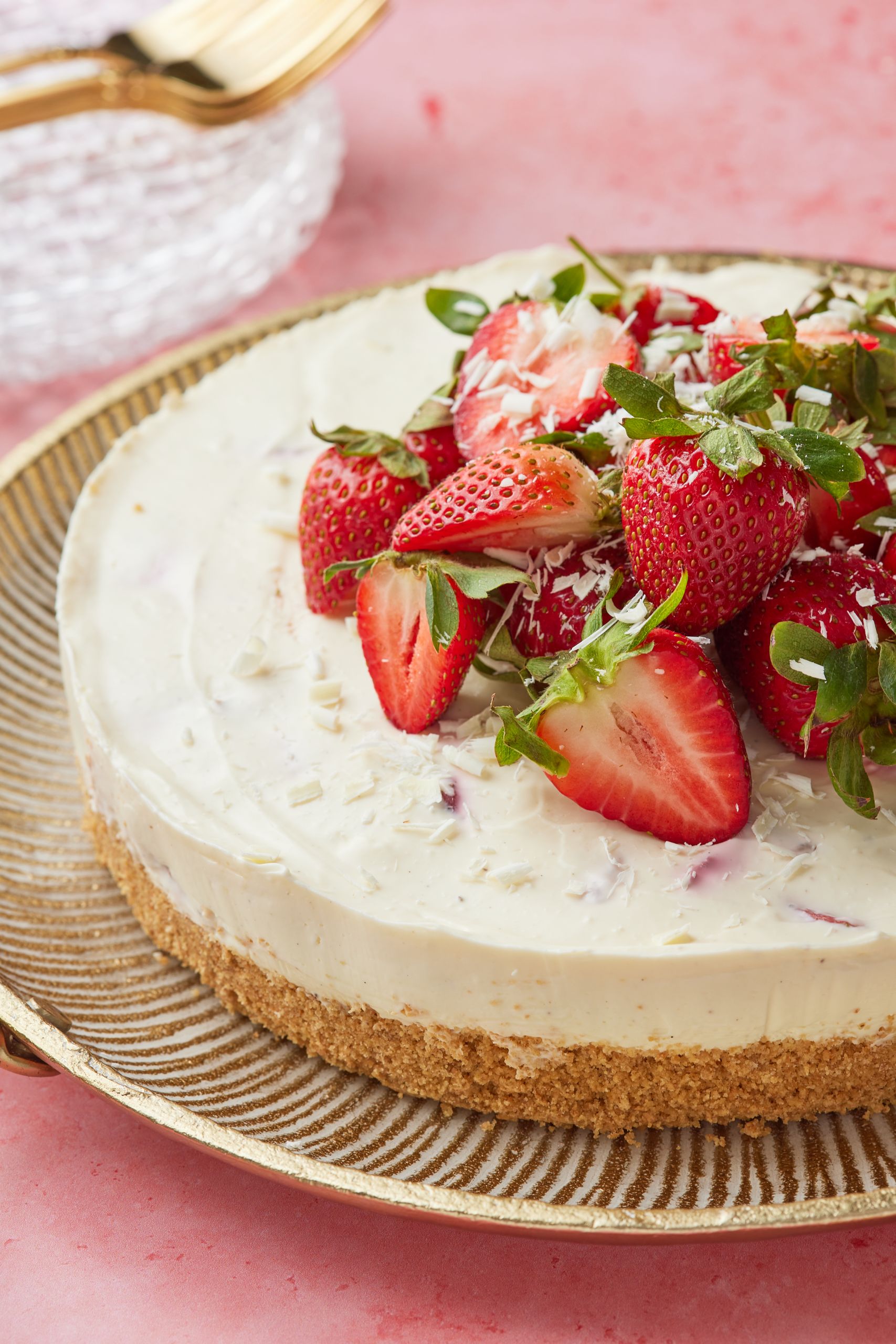Strawberry White Chocolate Cheesecake with fresh strawberries and white chocolate shavings on top.
