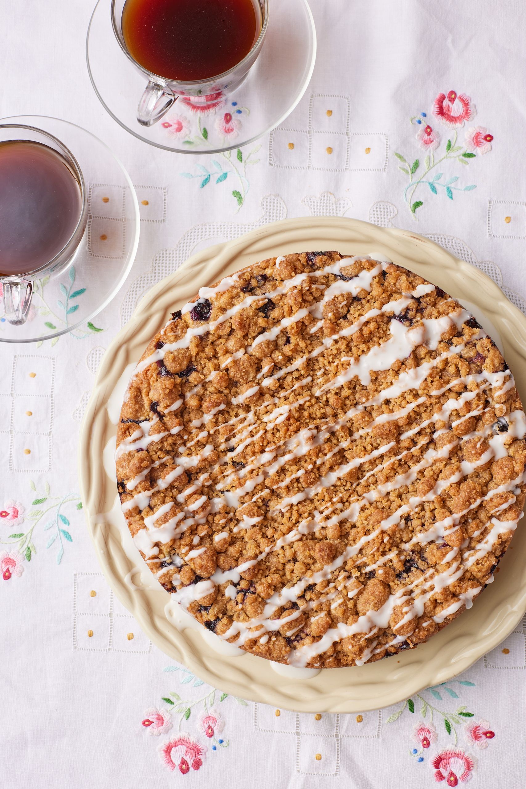 A top-down view of Blueberry Sour Cream Coffee Cake served with two cups of coffee. 