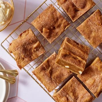 Top down view of squares of pumpkin blondies on the cooling rack , served with ice cream on the side.