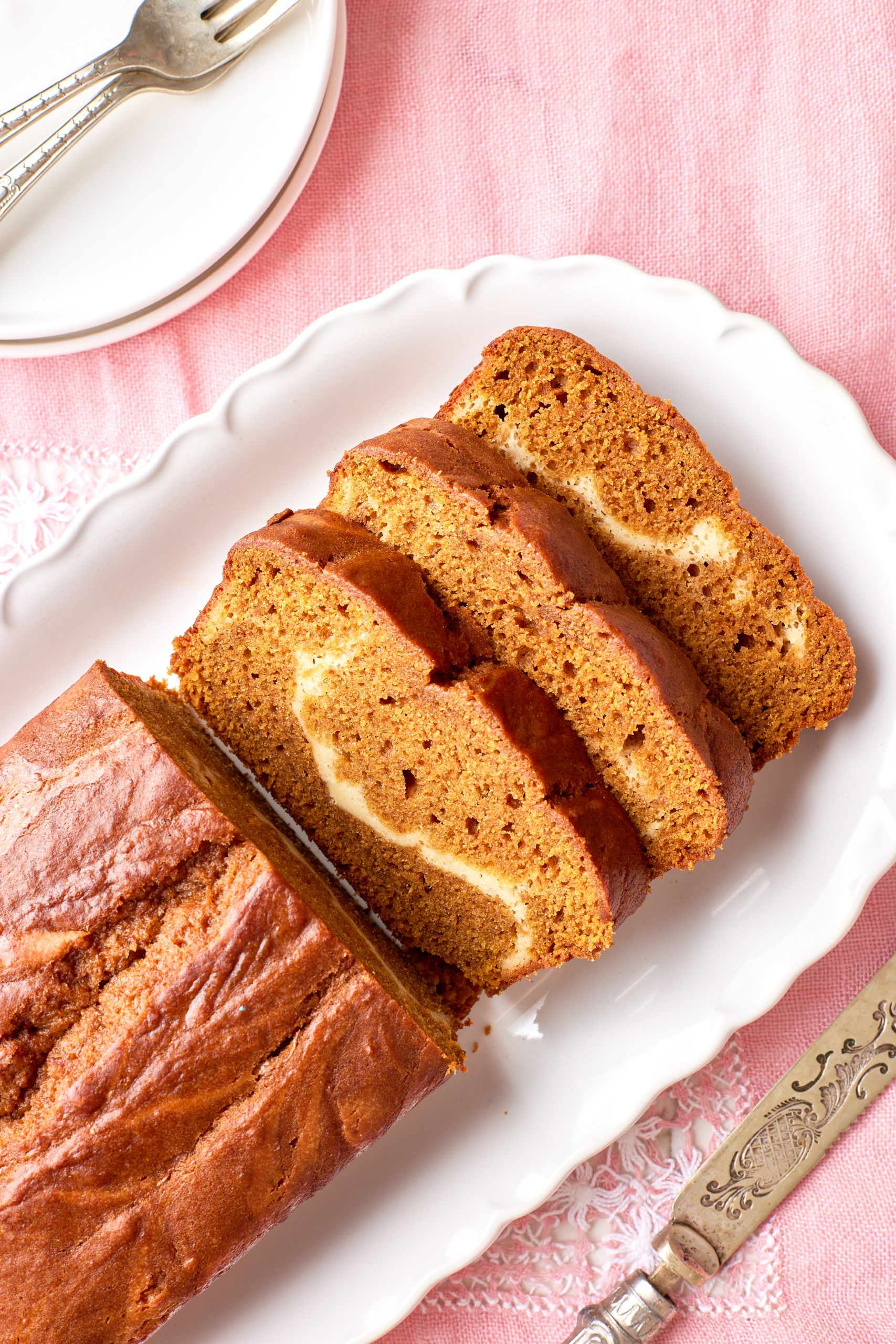 Pumpkin Cream Cheese bread on a platter, with half loaf sliced.