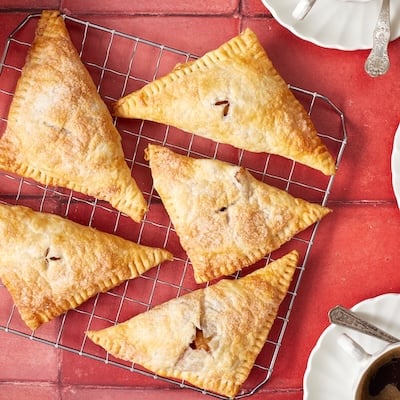 Apple turnovers on the cooling rack, served with coffee.