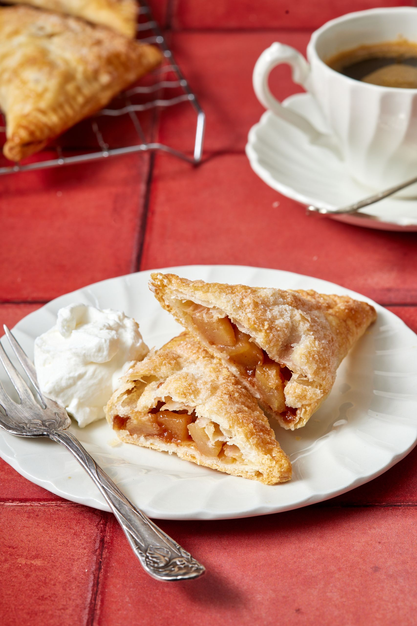 Apple turnovers served with whipped cream and coffee.