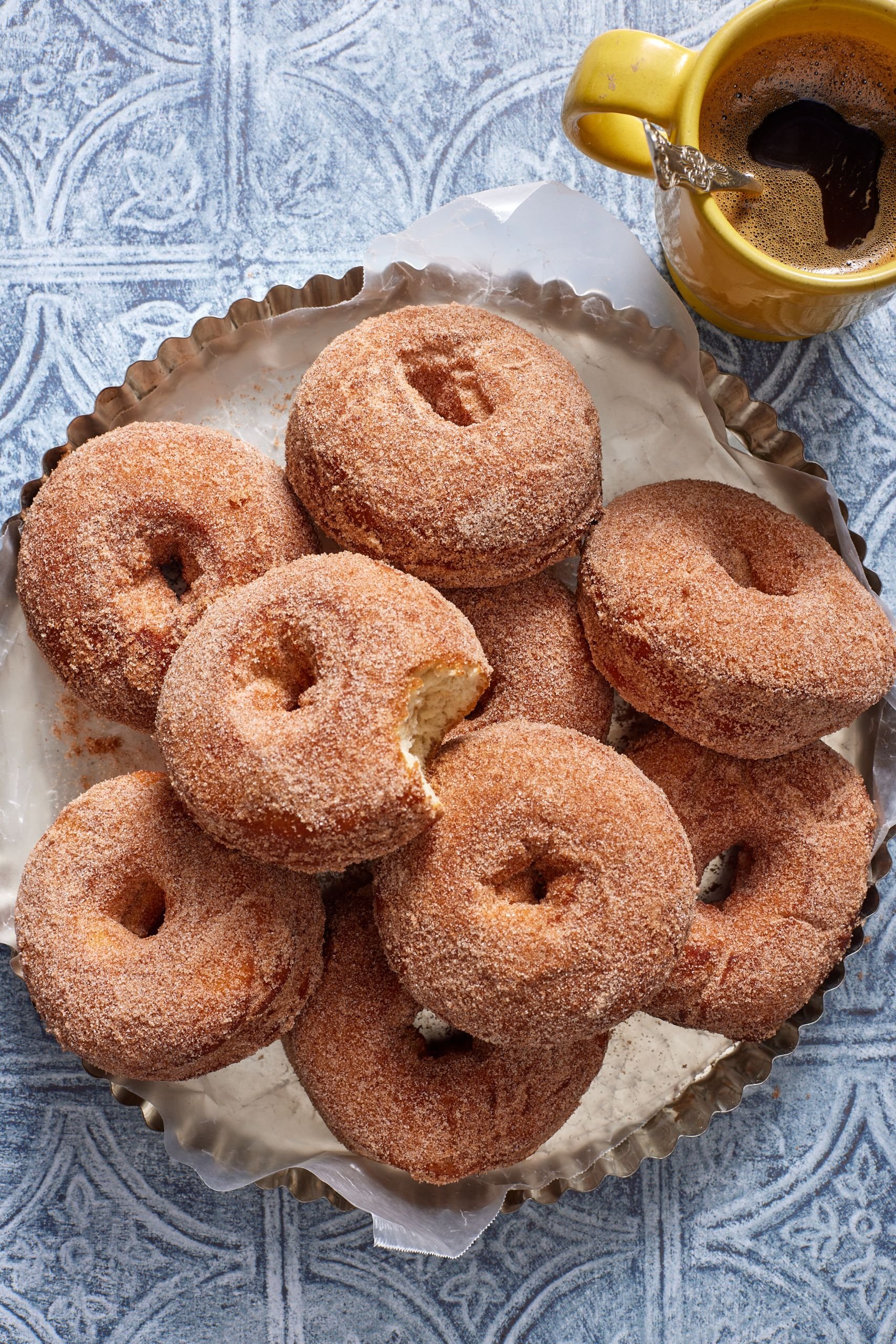 A platter of fluffy potato donuts covered with cinnamon sugar