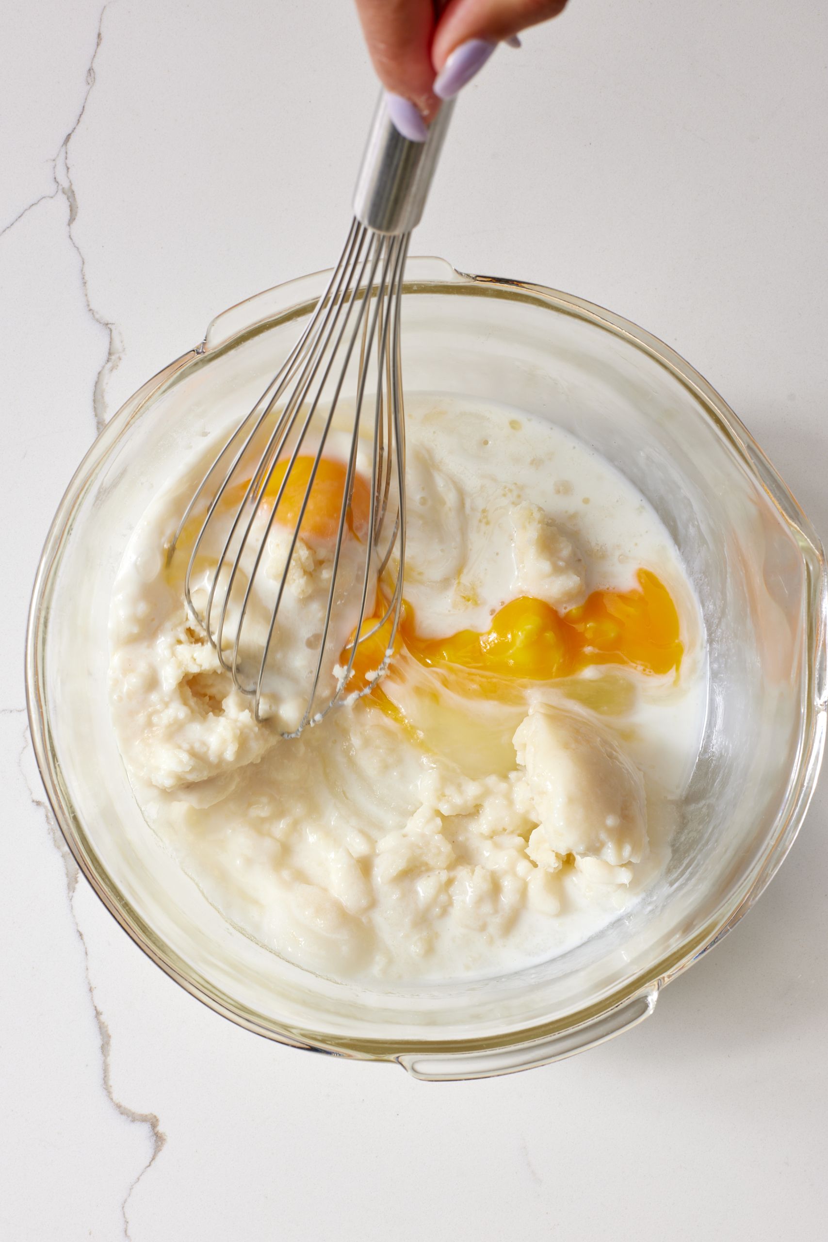 Step-by-step instructions on how to make potato donuts: whisk together wet ingredients.