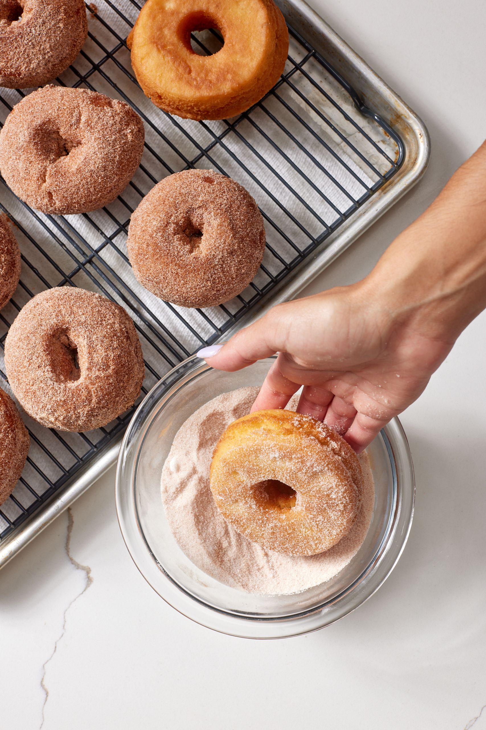 Drain excess oil on the rack then roll donuts in cinnamon sugar