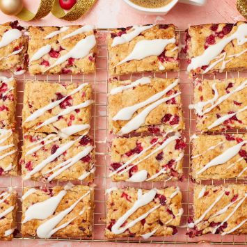 Top down view of squares of glazed Cranberry Bars on a wire rack.