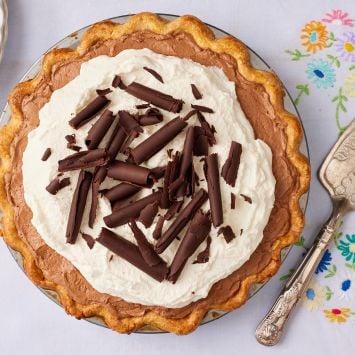 A top down view of French Silk Pie with golden crust, whipped cream, and chocolate shavings.