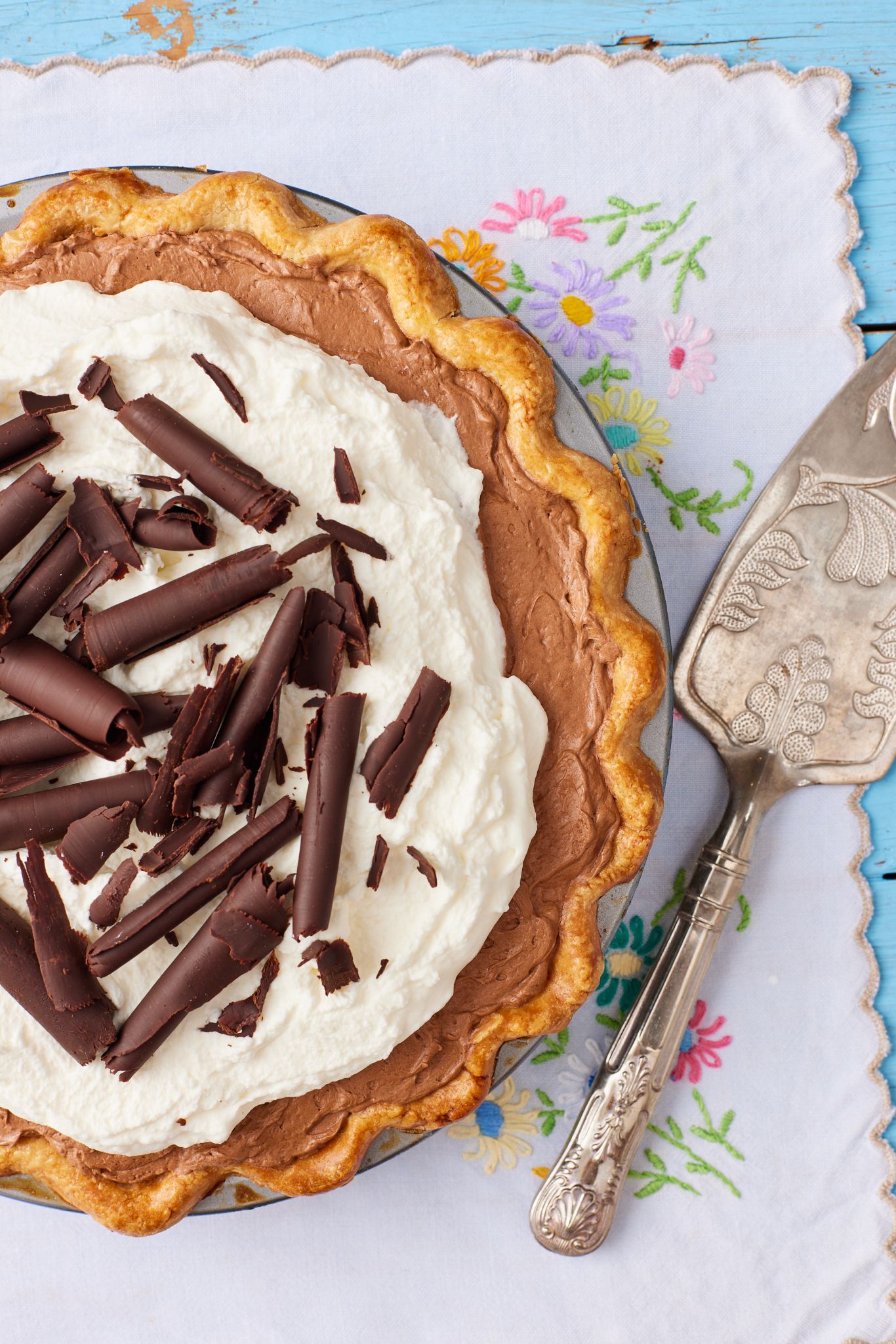 A top down view of French Silk Pie with golden crust, whipped cream, and chocolate shavings. 