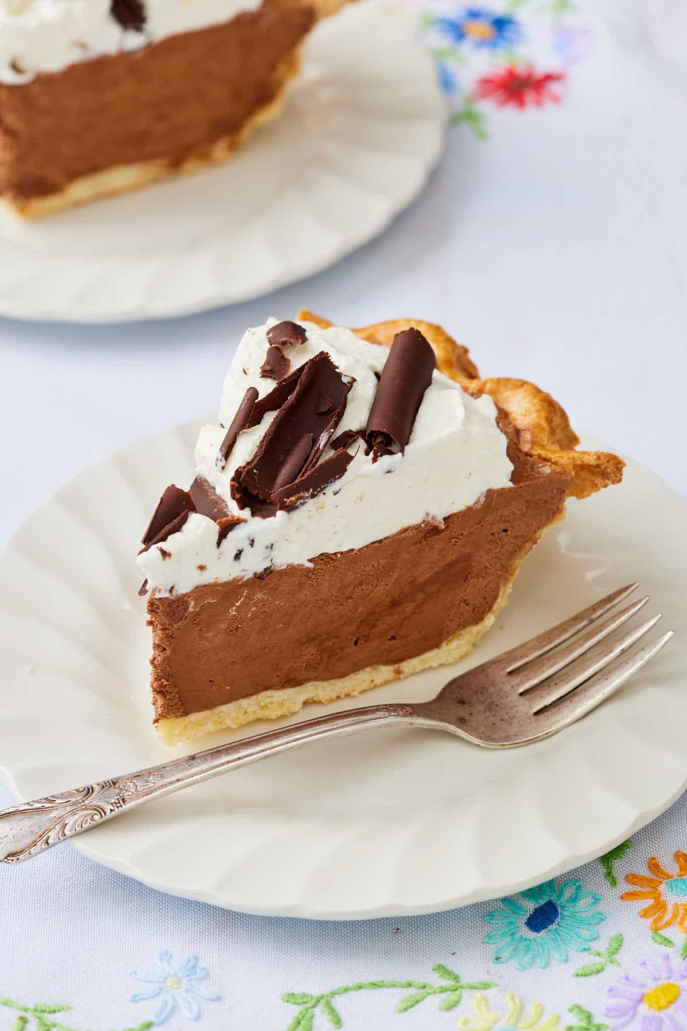 The side view of a slice of French Silk Pie served on a dessert plate shows its layers. 