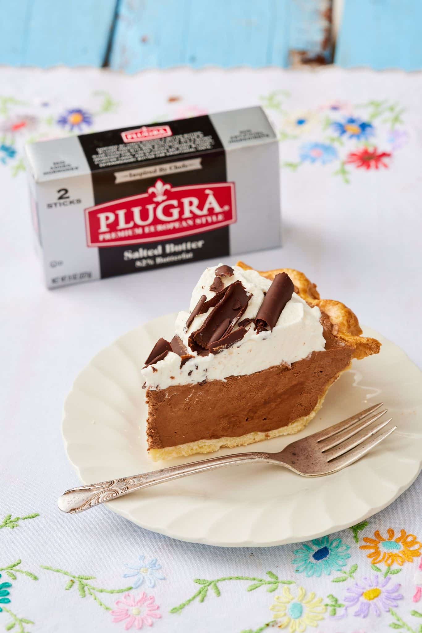 A slice of pie with a stick of butter behind it. 