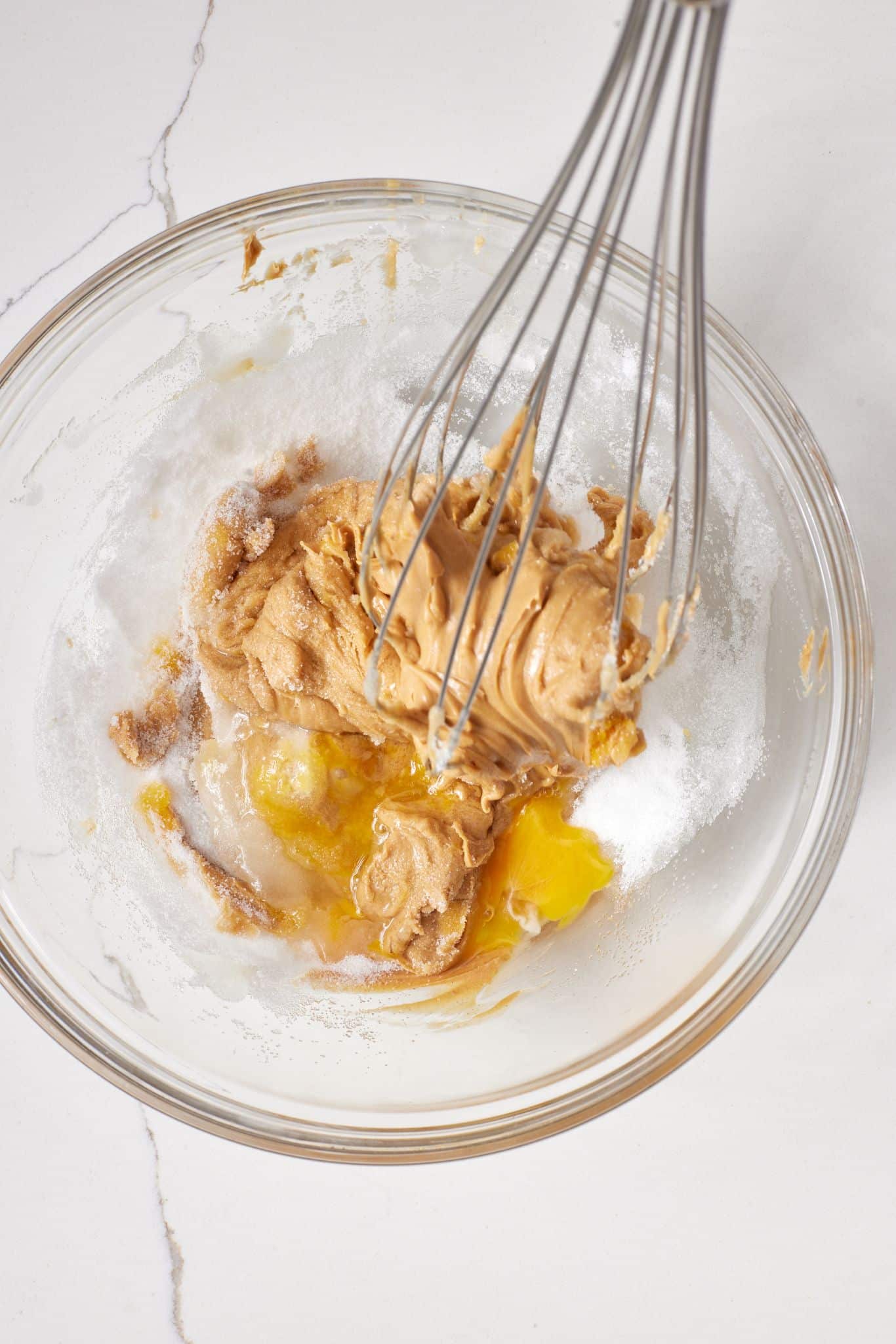 Step-by-step instructions on how to make Peanut Butter Blossoms: In a medium bowl, whisk together the egg, peanut butter, and ⅔ cup (5 oz/142 g) sugar until a dough forms.
