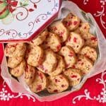 A tin of Fruitcake Cookies with two cup of coffee on the side.