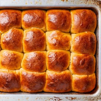 Top down view of golden brown Hawaiian Rolls in a baking pan.