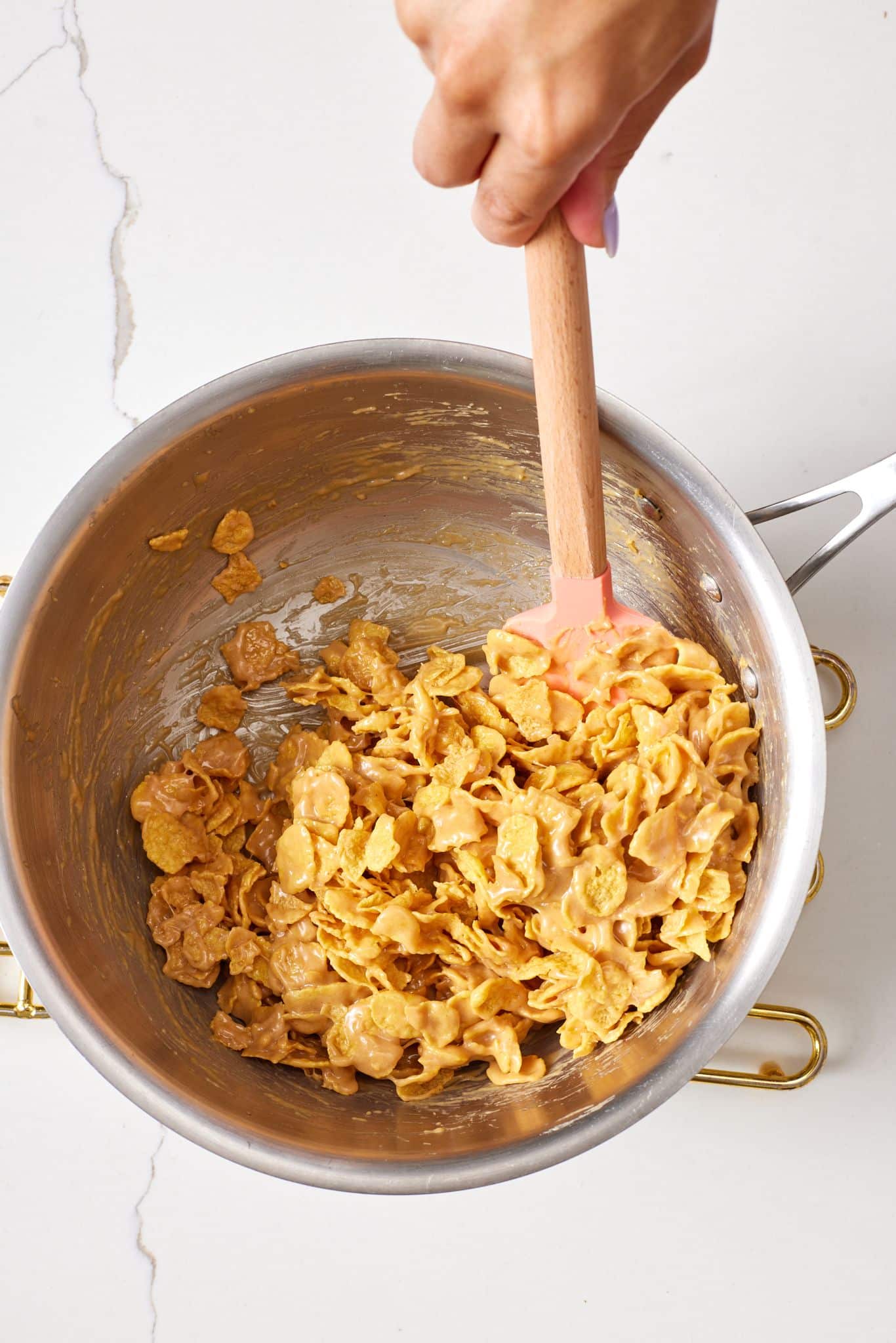 Add remaining ingredients: Remove from the heat and stir in the peanut butter and vanilla extract, then fold in the cornflakes.