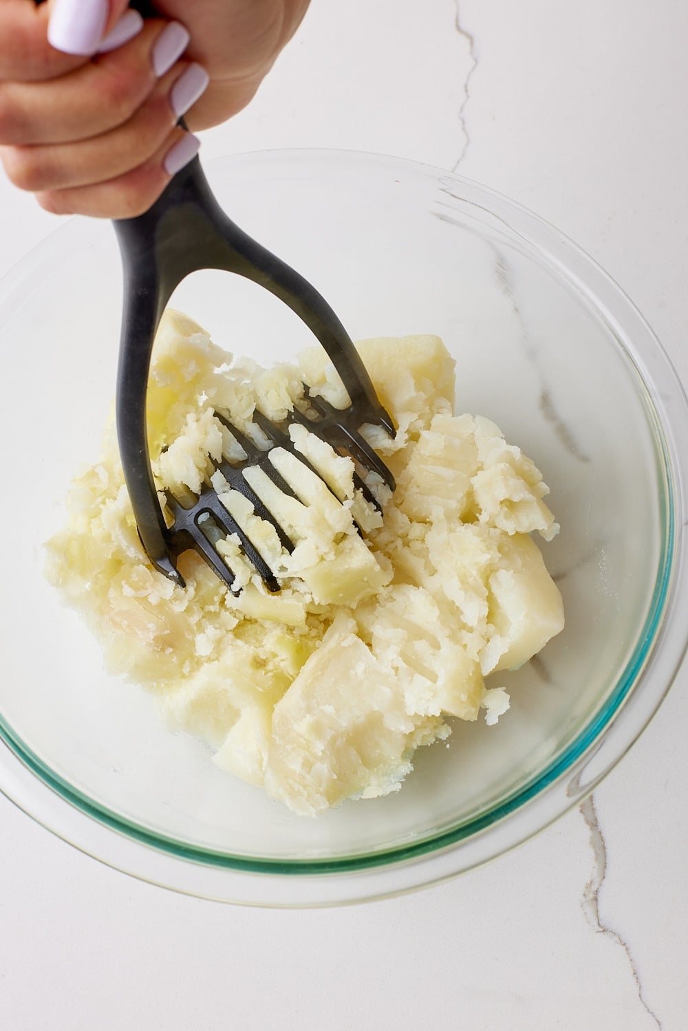 Cheese and Onion Rolls5 Mash potatoes with a masher in a large bowl.